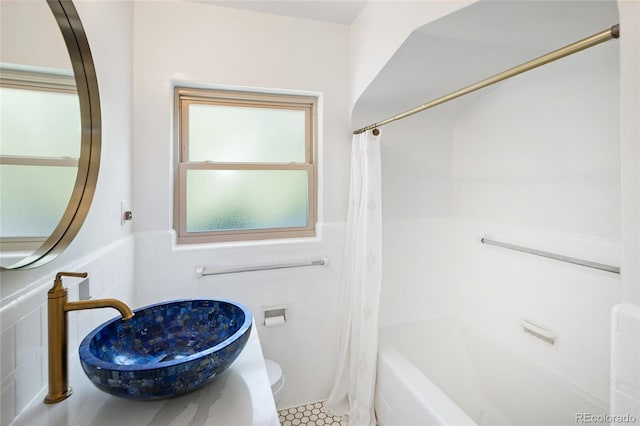 1661 Oneida St, Denver, CO 80220 - bathroom featuring tile walls, shower / bath combo with shower curtain, tile patterned flooring, and a wainscoted wall