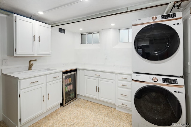 1661 Oneida St, Denver, CO 80220 - washroom featuring estacked washer and dryer, beverage cooler, recessed lighting, and cabinet space