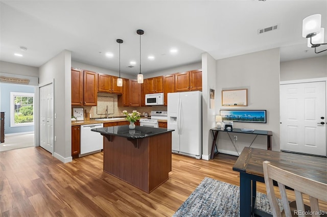 16600 Las Ramblas Ln Unit A, Parker, CO 80134 - kitchen with white appliances, light wood finished floors, a kitchen island, hanging light fixtures, and recessed lighting
