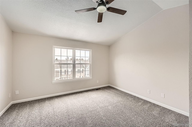 unfurnished room featuring ceiling fan, vaulted ceiling, a textured ceiling, and carpet