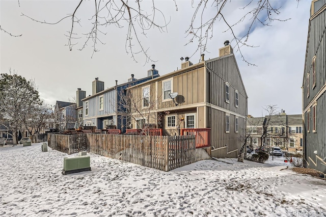 snow covered property with central AC unit