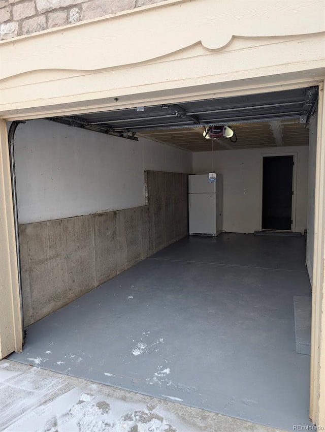 garage featuring a garage door opener and white fridge