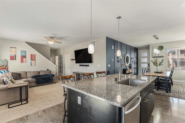 10796 Truckee Cir, Commerce City, CO 80022 - kitchen featuring a sink, a kitchen bar, dark wood-style flooring, a center island with sink, and a ceiling fan