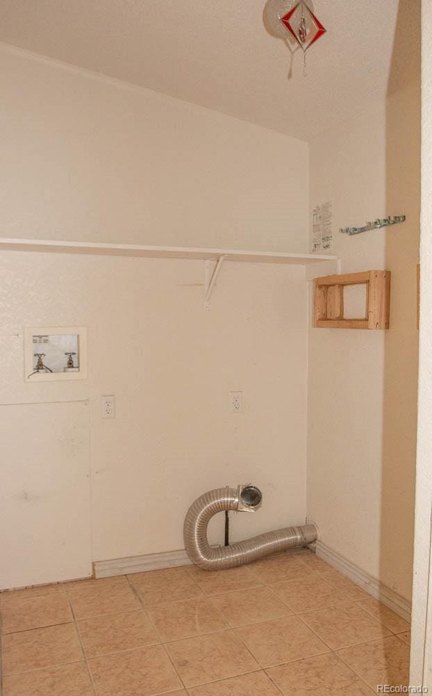 washroom with washer hookup and light tile floors