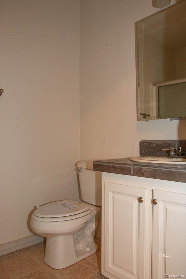 bathroom with vanity, toilet, and tile flooring