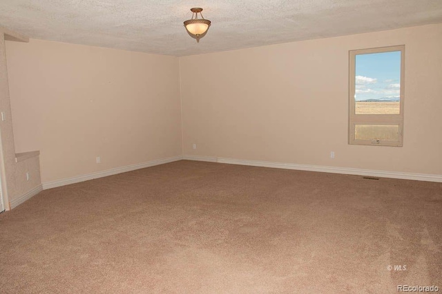 unfurnished room with a textured ceiling and carpet floors