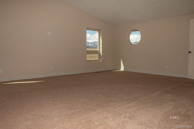 carpeted empty room with vaulted ceiling