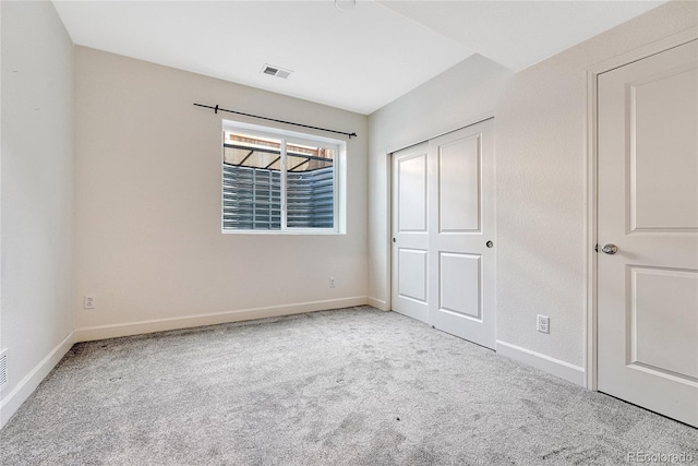 unfurnished bedroom featuring a closet and light colored carpet