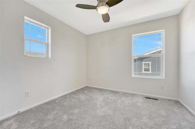 spare room with plenty of natural light, carpet, and ceiling fan