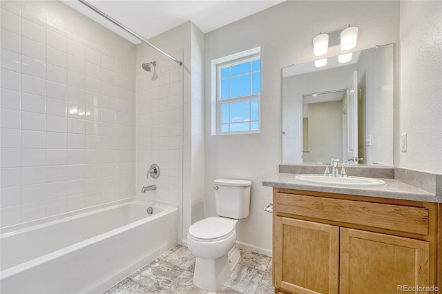 full bathroom featuring tile patterned flooring, toilet, vanity, and tiled shower / bath