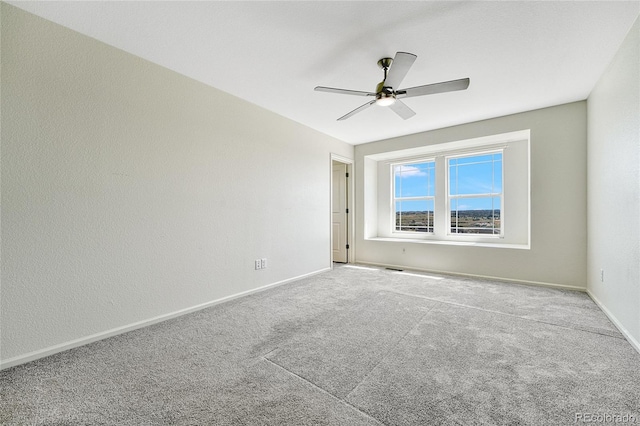 carpeted spare room featuring ceiling fan