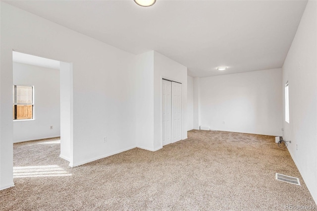 spare room featuring light colored carpet