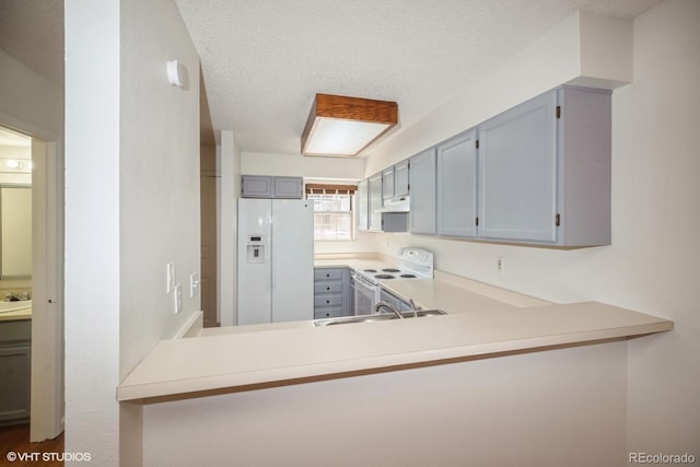 kitchen with kitchen peninsula, a textured ceiling, white appliances, sink, and gray cabinets