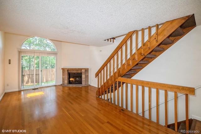 unfurnished living room with wood-type flooring and a textured ceiling