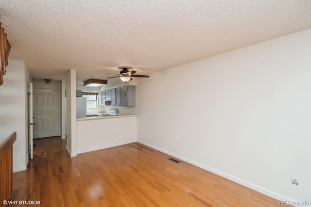 interior space with hardwood / wood-style floors, a textured ceiling, and ceiling fan