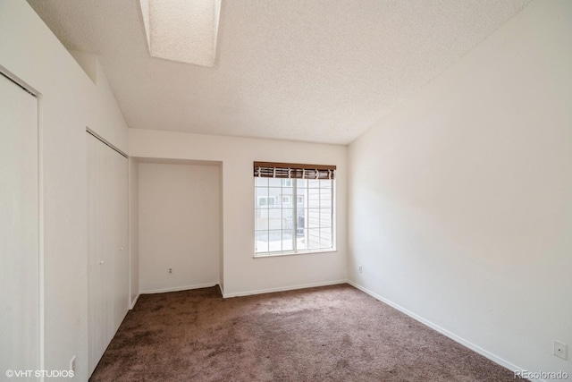 carpeted spare room with a textured ceiling