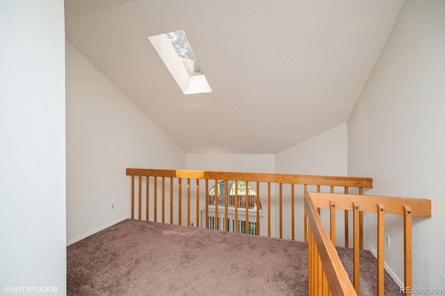 corridor with carpet and lofted ceiling with skylight