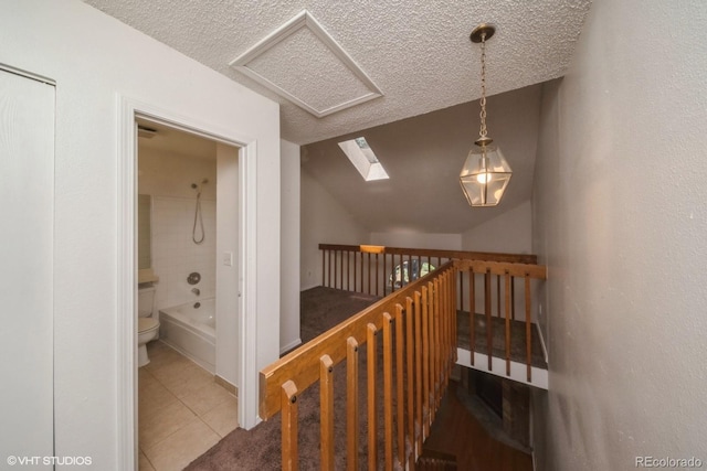 stairs with tile patterned flooring, a textured ceiling, and vaulted ceiling