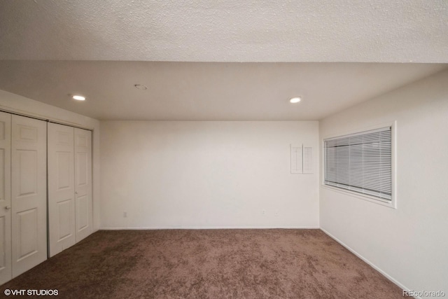 unfurnished bedroom featuring carpet, a textured ceiling, and a closet