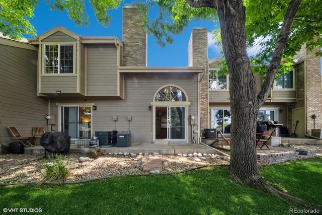 back of house featuring cooling unit, a yard, and a patio