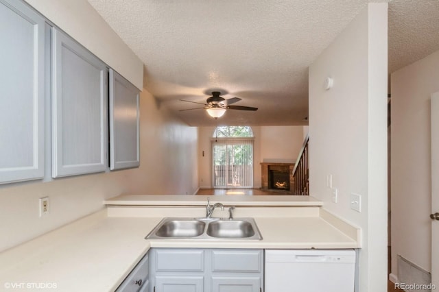 kitchen featuring a textured ceiling, dishwasher, ceiling fan, and sink