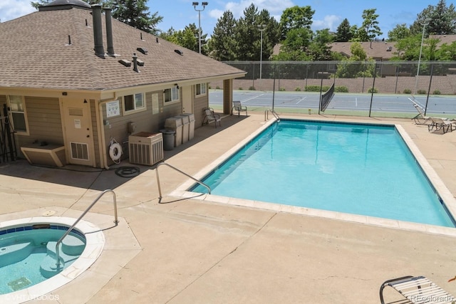 view of pool featuring a patio area, a fenced in pool, a hot tub, and fence