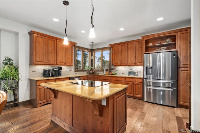 1524 Fox Acres Dr Unit 412, Red Feather Lakes, CO 80545 - kitchen featuring stainless steel refrigerator with ice dispenser, black electric cooktop, light wood-type flooring, open shelves, and brown cabinetry