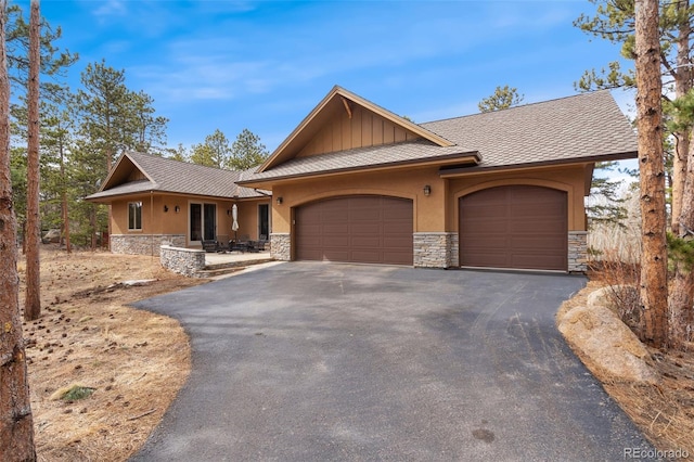 1524 Fox Acres Dr Unit 412, Red Feather Lakes, CO 80545 - view of front of home featuring stone siding, asphalt driveway, a garage, and stucco siding