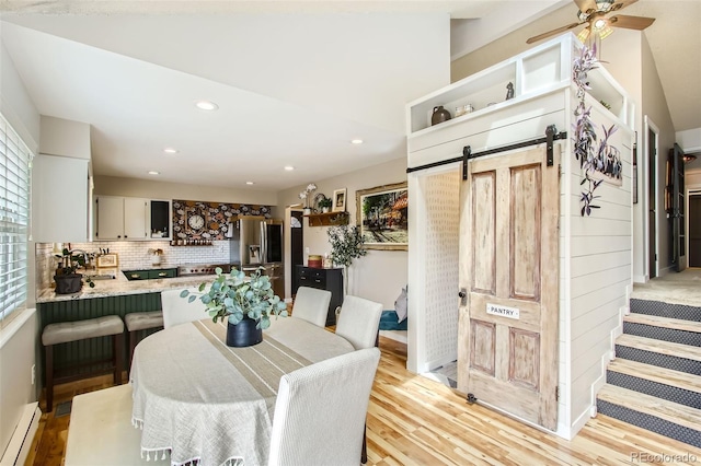 16626 Ouray Rd W, Pine, CO 80470 - dining space featuring baseboard heating, a barn door, light wood finished floors, recessed lighting, and a ceiling fan