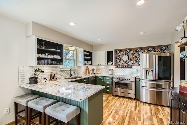 16626 Ouray Rd W, Pine, CO 80470 - kitchen with appliances with stainless steel finishes, open shelves, a peninsula, light stone countertops, and a kitchen breakfast bar