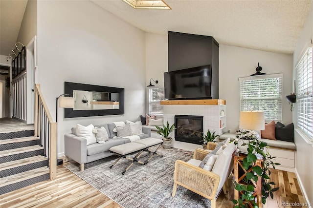 16626 Ouray Rd W, Pine, CO 80470 - living area with wood finished floors, a tiled fireplace, and high vaulted ceiling