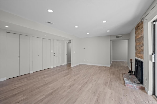 unfurnished living room with light wood-type flooring and a fireplace