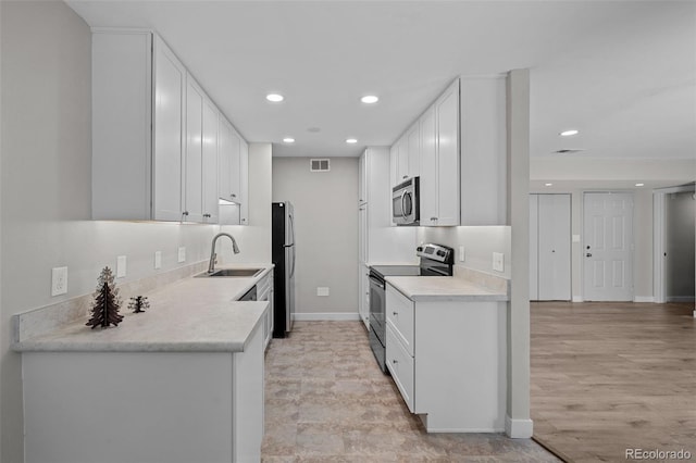 kitchen featuring white cabinets, light wood-type flooring, stainless steel appliances, and sink