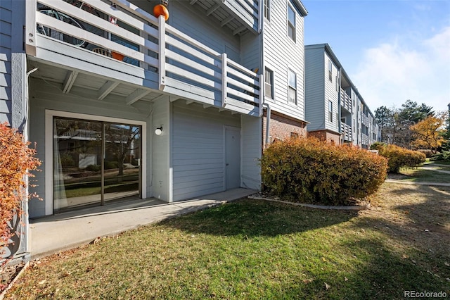 property entrance featuring a lawn and a balcony