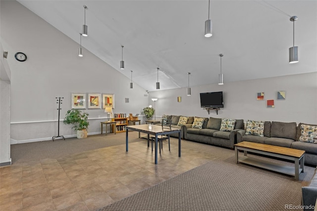 carpeted living room with high vaulted ceiling