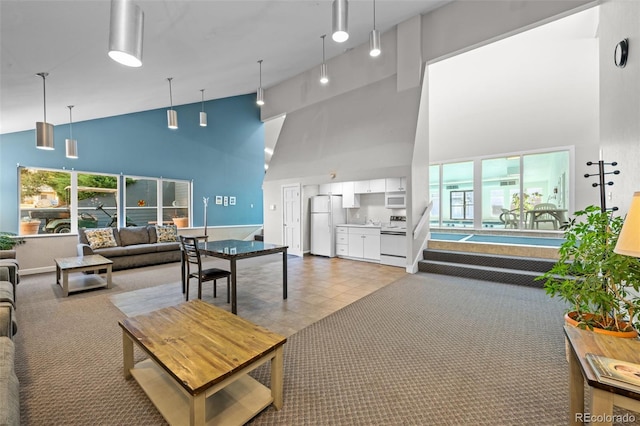 living room featuring light carpet, high vaulted ceiling, and a healthy amount of sunlight