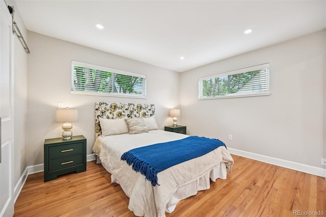 2880 S High St, Denver, CO 80210 - bedroom with a barn door, multiple windows, light wood-style flooring, and recessed lighting