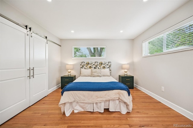 2880 S High St, Denver, CO 80210 - bedroom featuring a barn door, light wood-type flooring, and recessed lighting