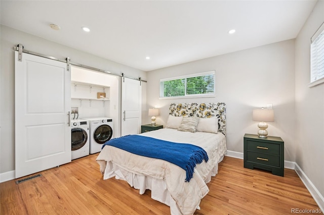 2880 S High St, Denver, CO 80210 - bedroom with washer and dryer, a barn door, light wood-style floors, and recessed lighting