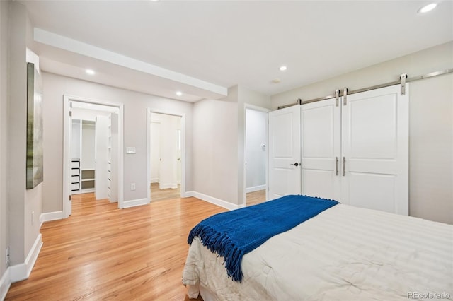 2880 S High St, Denver, CO 80210 - bedroom featuring light wood-type flooring, recessed lighting, a barn door, and a walk in closet