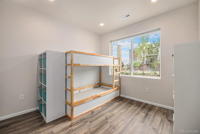 unfurnished bedroom featuring recessed lighting, visible vents, baseboards, and wood finished floors