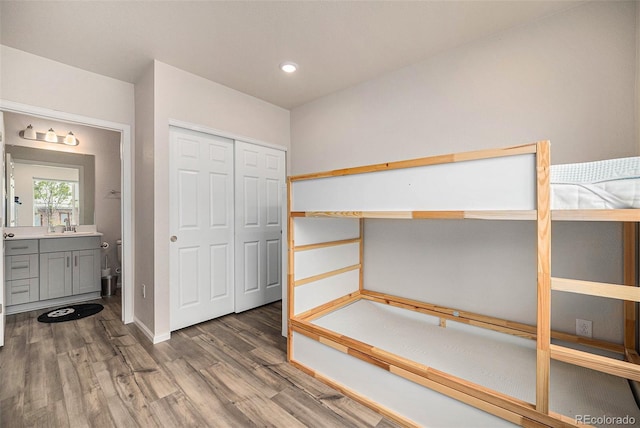 unfurnished bedroom featuring recessed lighting, a closet, baseboards, and wood finished floors