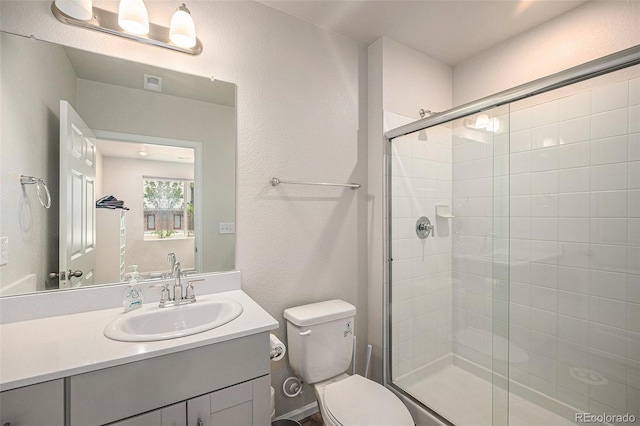 full bathroom featuring visible vents, a shower stall, toilet, and vanity