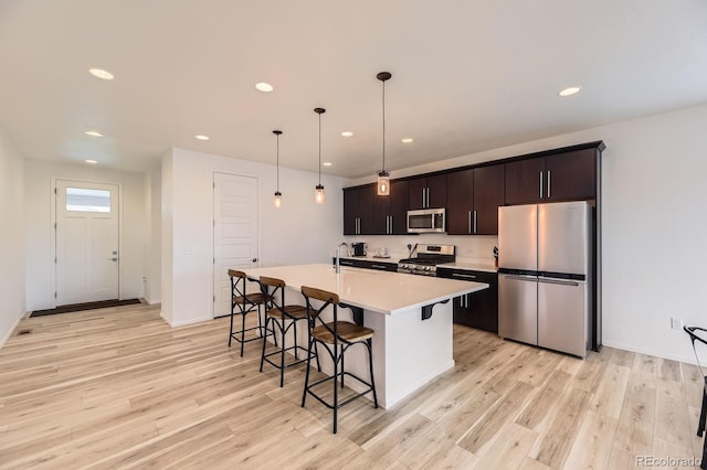 1420 E Witherspoon Dr, Elizabeth, CO 80107 - kitchen with stainless steel appliances, a breakfast bar area, recessed lighting, an island with sink, and light countertops