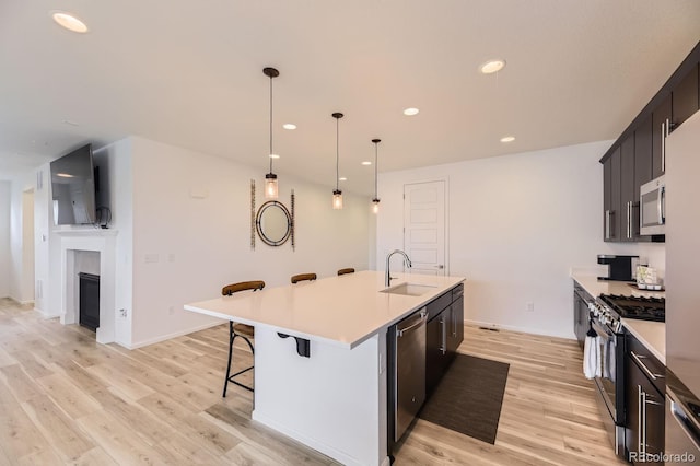 1420 E Witherspoon Dr, Elizabeth, CO 80107 - kitchen featuring a sink, stainless steel appliances, a breakfast bar area, light wood finished floors, and light countertops