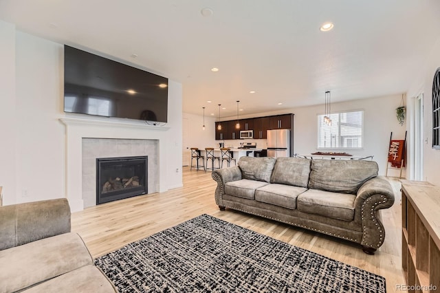 1420 E Witherspoon Dr, Elizabeth, CO 80107 - living area with light wood finished floors, a tile fireplace, and recessed lighting