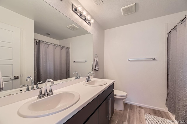 1420 E Witherspoon Dr, Elizabeth, CO 80107 - bathroom with wood finished floors, double vanity, toilet, baseboards, and curtained shower