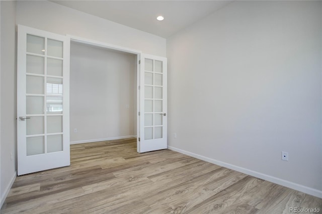 spare room with french doors and light hardwood / wood-style floors