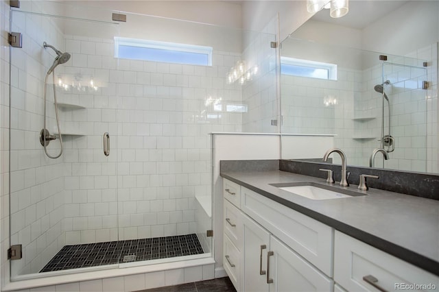 bathroom with vanity, a wealth of natural light, and a shower with shower door