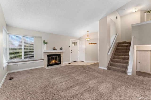 11532 Newland St, Westminster, CO 80020 - unfurnished living room featuring carpet flooring, a fireplace, stairway, a textured ceiling, and lofted ceiling
